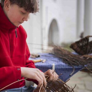 Junger Korbflechter beim Kinderhandwerksmarkt