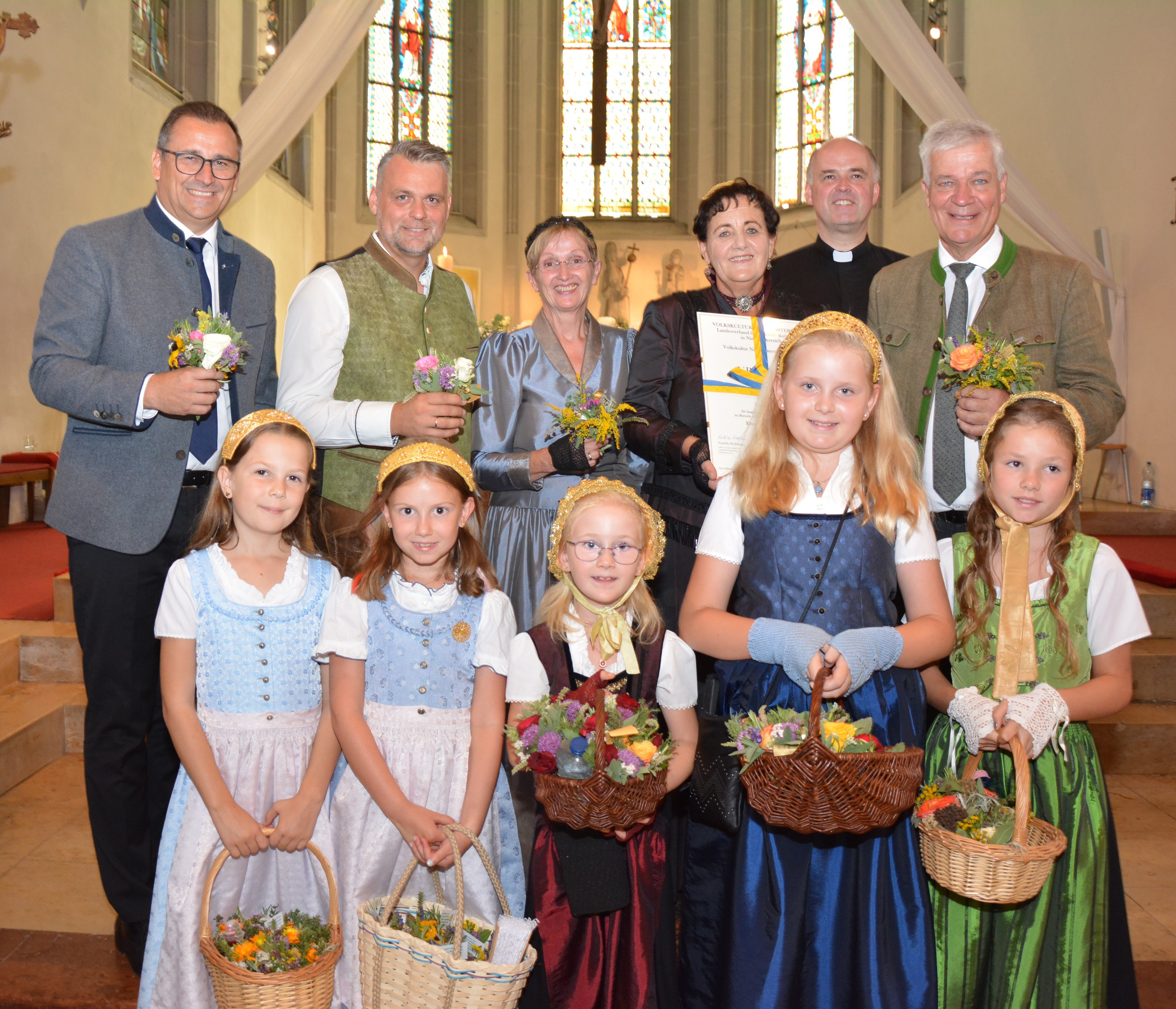 Harald Froschauer, Geschäftsführer der Volkskultur Niederösterreich, Lukas Michlmayr, Bürgermeister der Stadt Haag, Goldhaubenobfrau Daniela Heinzl, Maria Sturm, Obfrau der Goldhaubengruppe Haag, Pfarrer Helmut Prader und Landtagsabgeordneter Anton Kasser sowie einige Goldhaubenmädchen mit den Kräutersträußchen bei der Goldhaubenwallfahrt in der Stadt Haag.