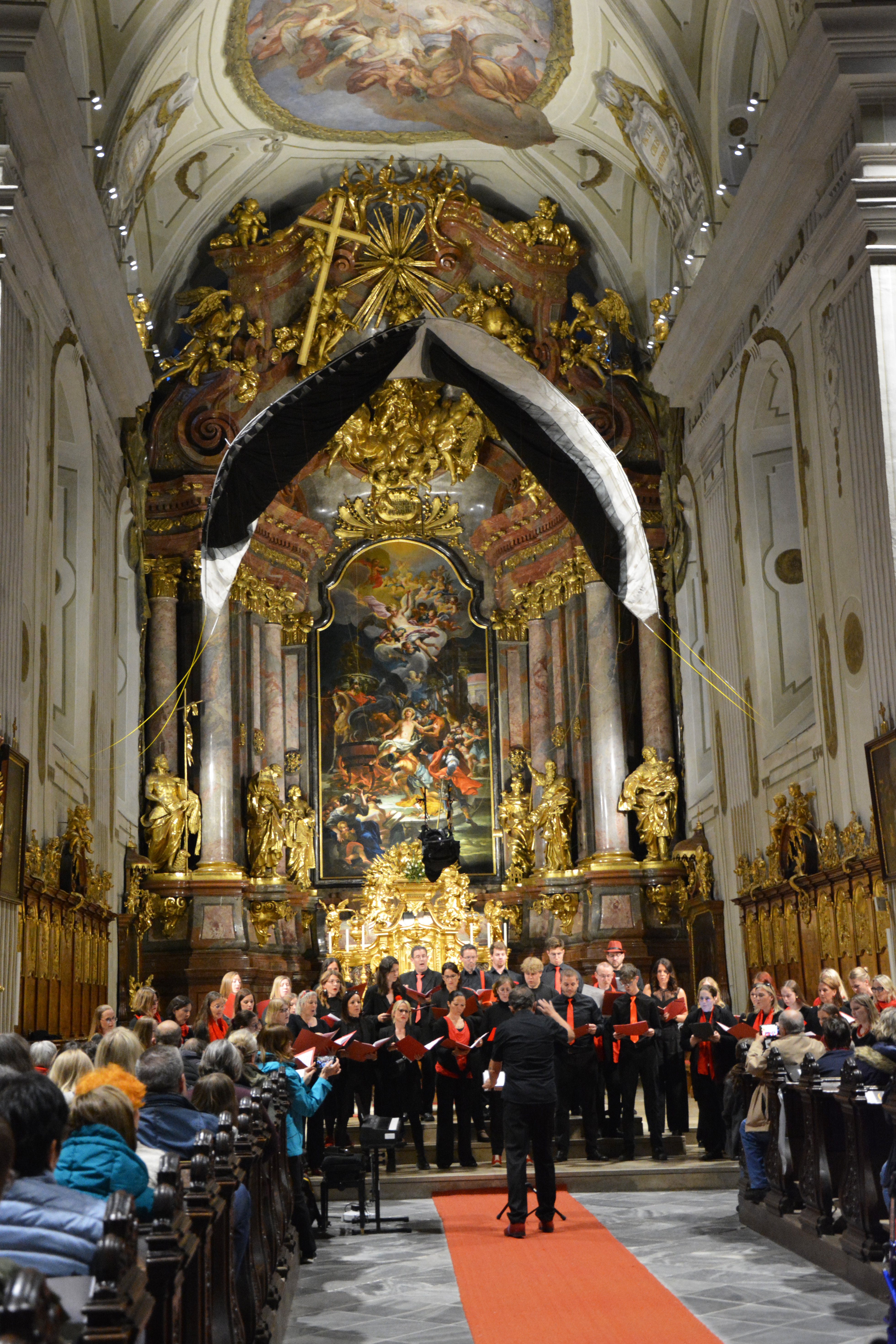 Der Chor CANTARE vor der vollen Stadtpfarrkirche St. Veit in Krems.